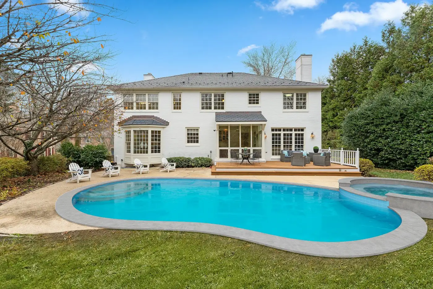 White house with a backyard swimming pool and deck