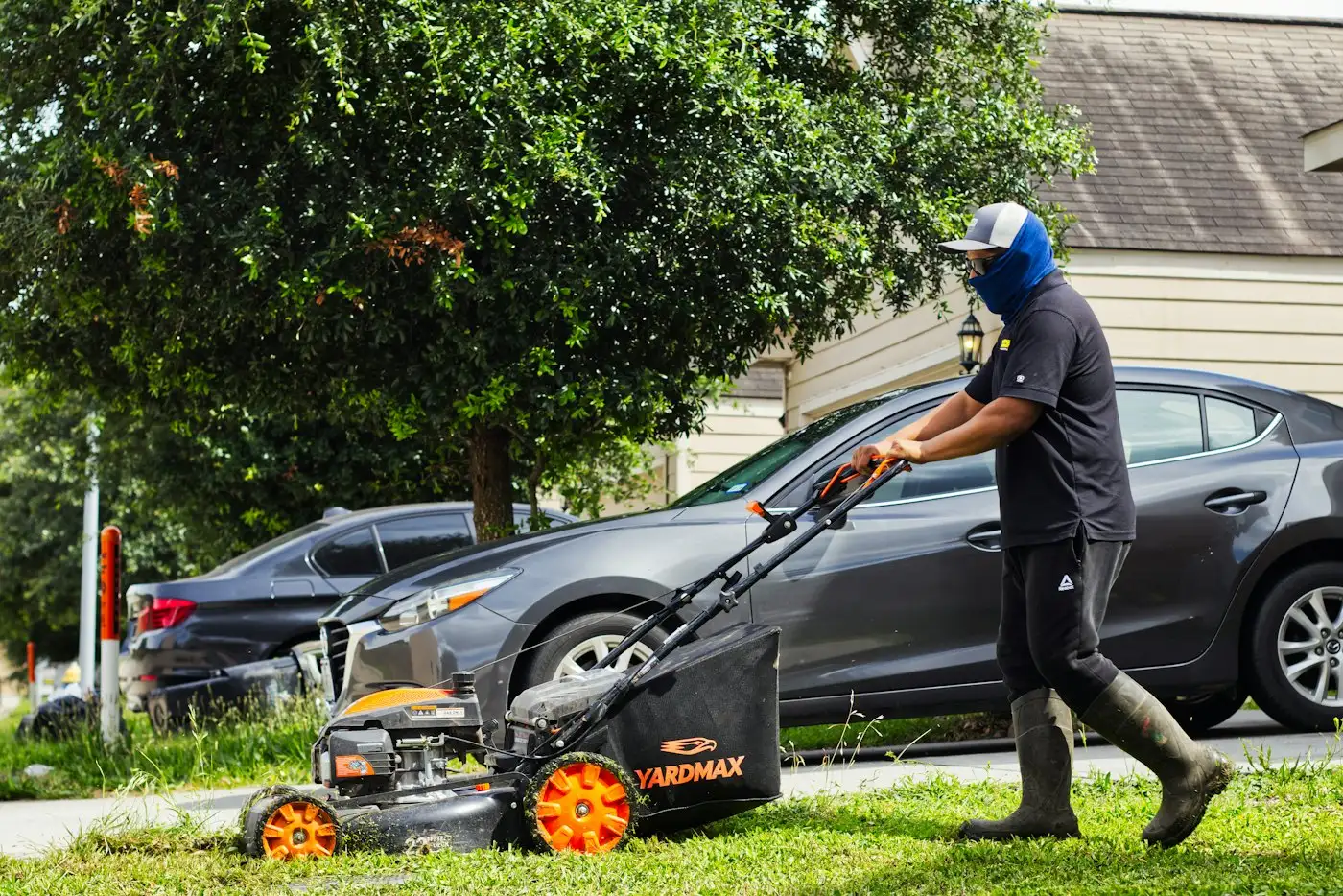 A man mows a lawn with a push mower