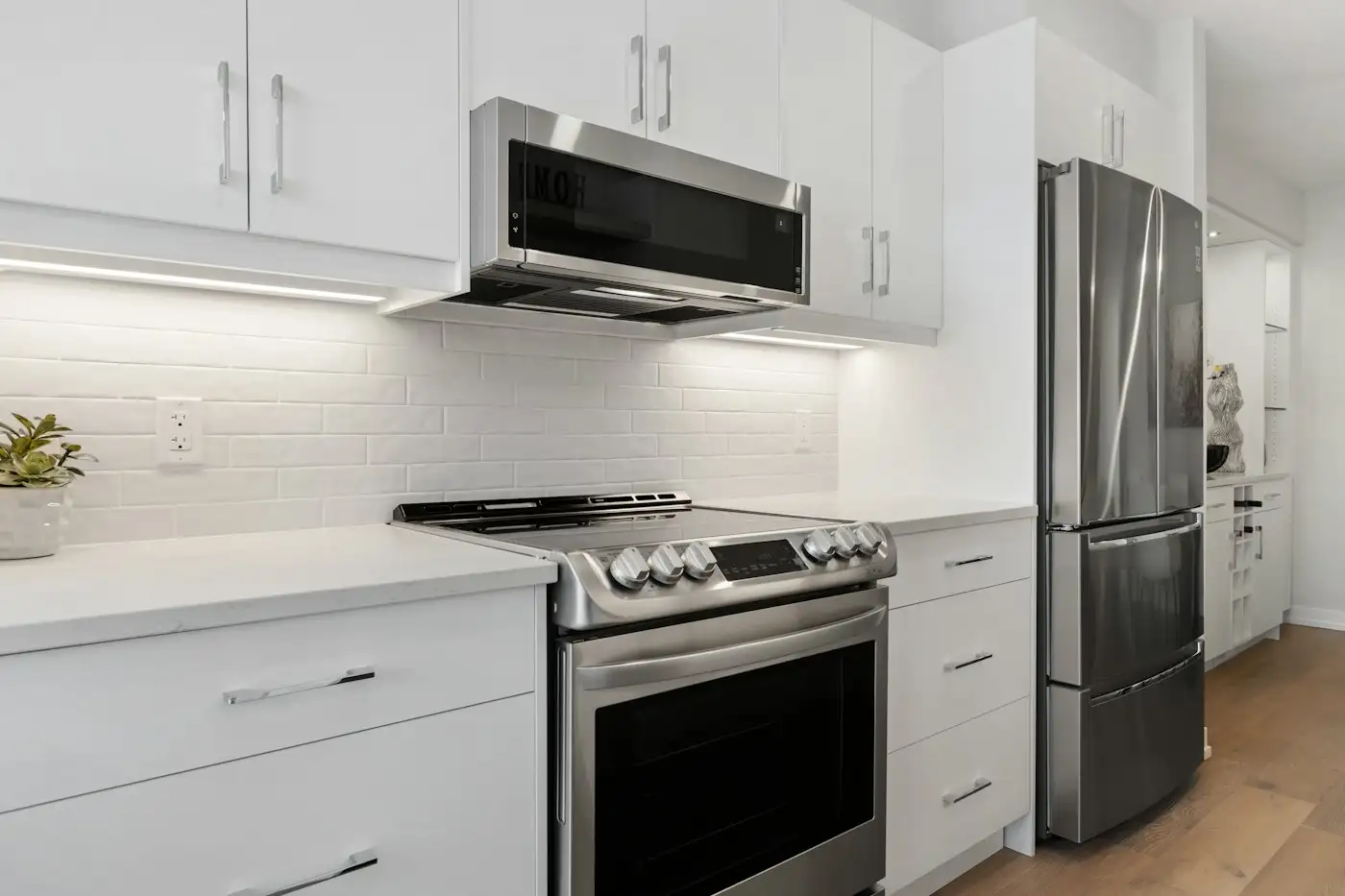 A kitchen with white cabinets and stainless steel appliances