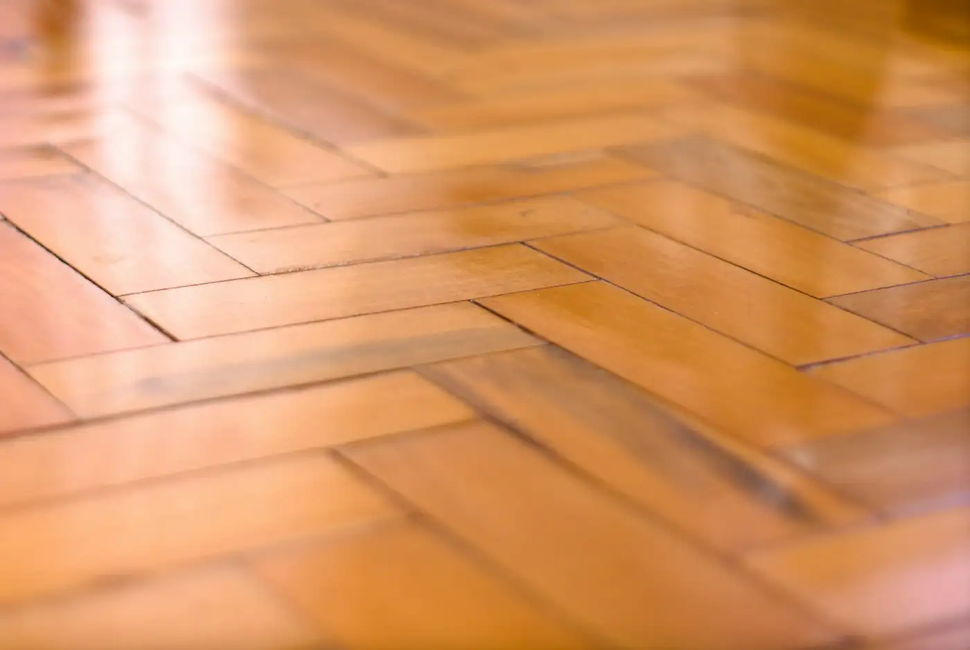 Shiny wooden floor with a classic herringbone pattern