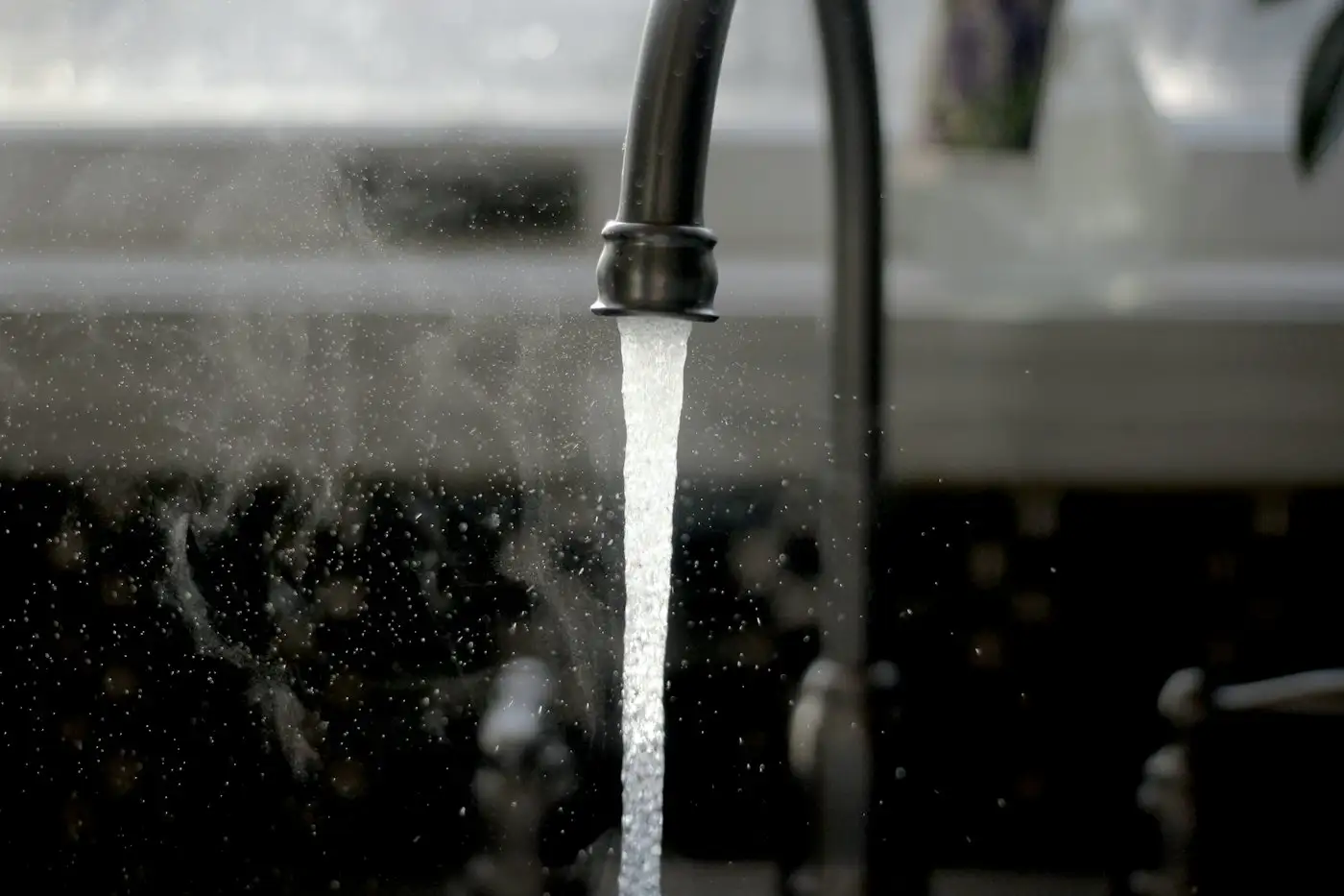 A faucet running water from a kitchen sink