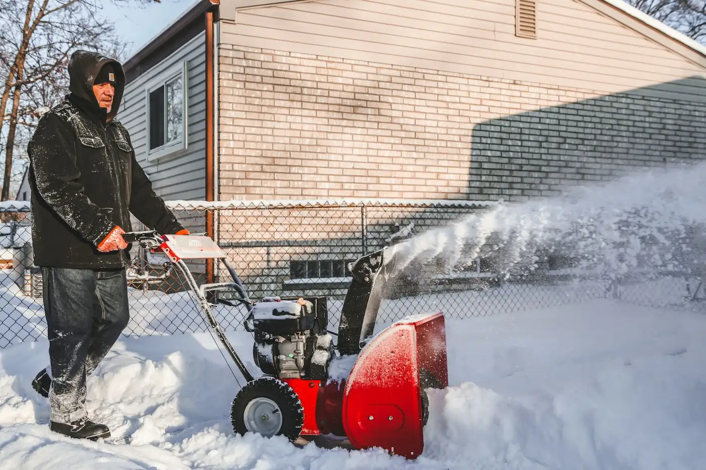 Person clearing snow with a red two-stage snow blower
