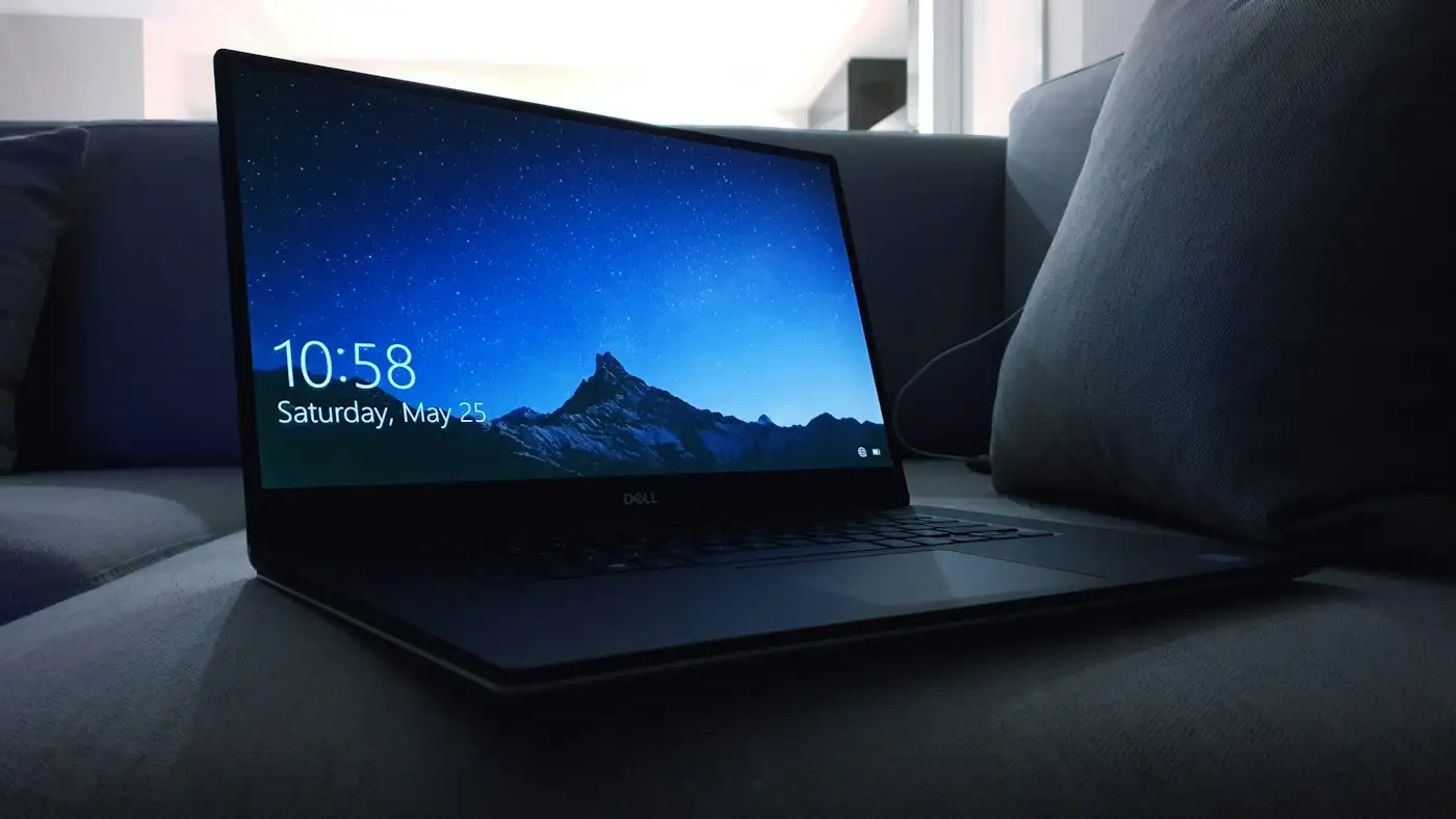Black dell laptop on sofa