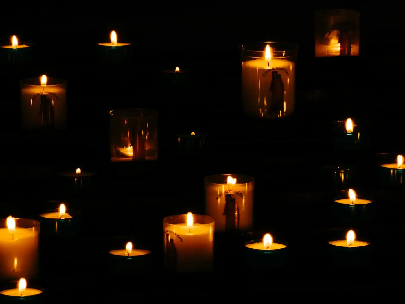 Lit yellow candles in the dark